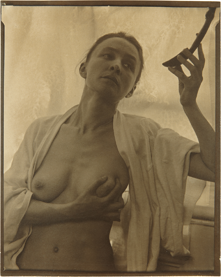 Georgia O'Keeffe in black cape and hat, photographed by Alfred Stieglitz, 1920–1922