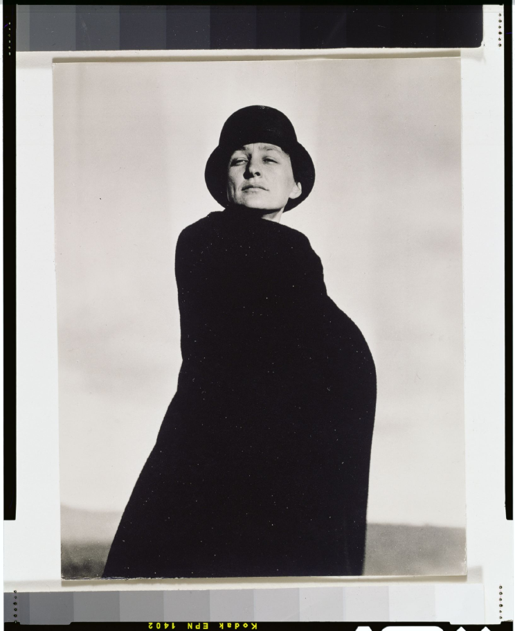 Georgia O'Keeffe in black cape and hat, photographed by Alfred Stieglitz, 1920–1922